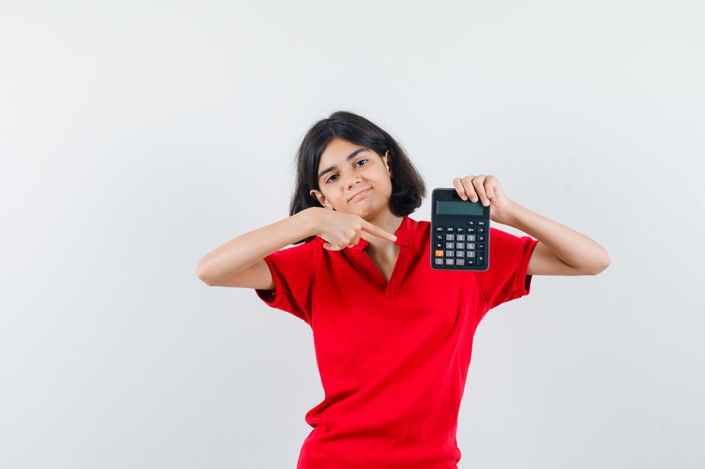 A woman holding up a calculator and pointing to it